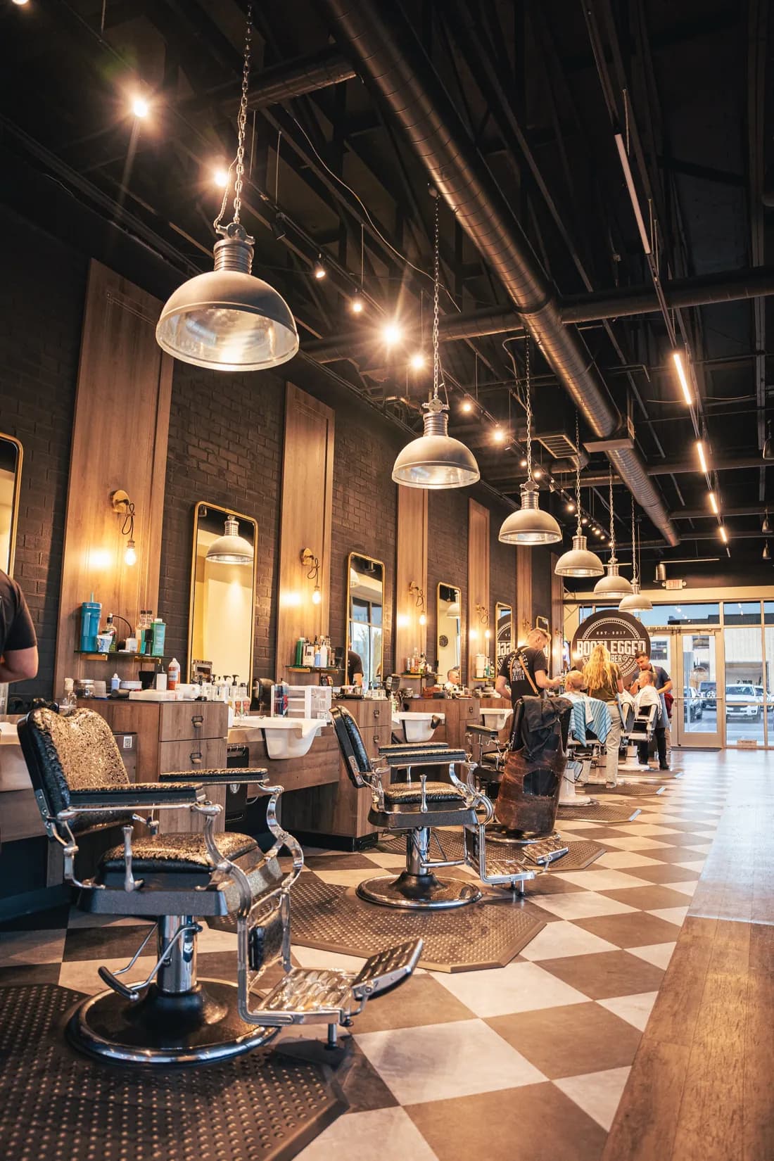 The Herriman shop floor: a row of barber chairs under pendant lights